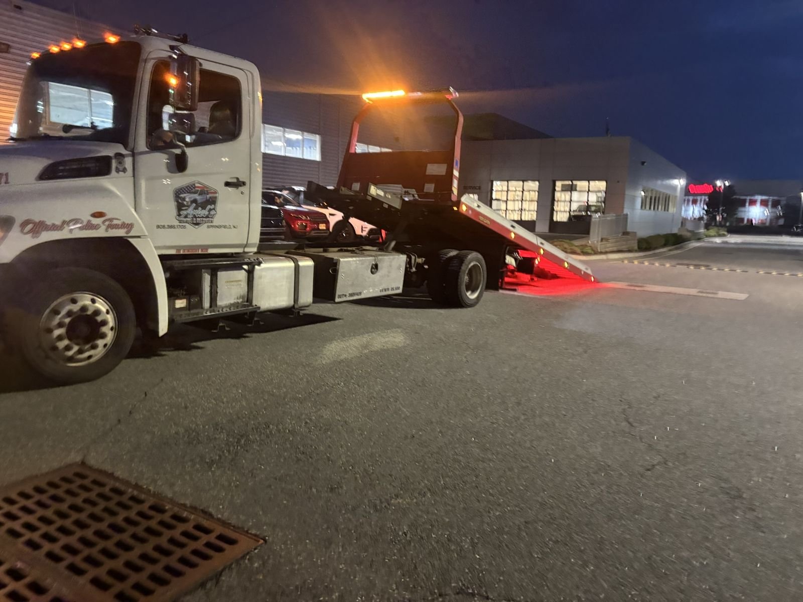 Ariel's Towing flatbed loading a car at night in Garwood, NJ